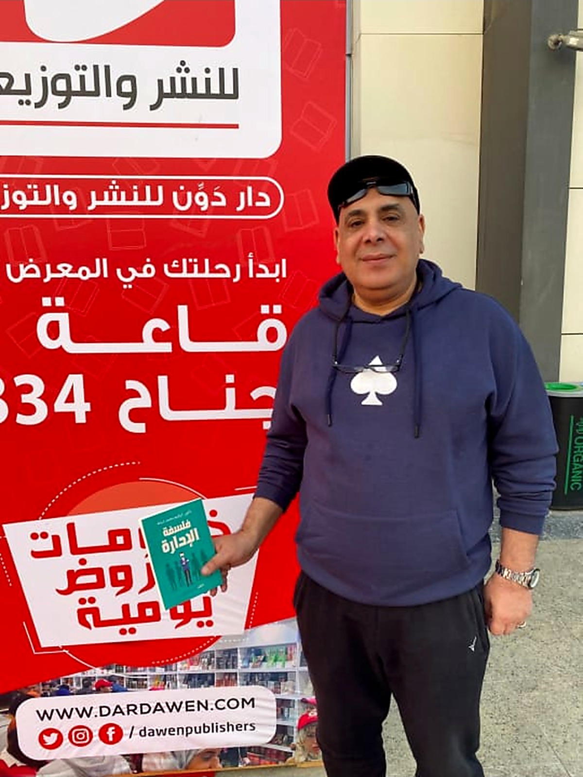 الدكتور إبراهيم شبانة يحمل نسخة من كتاب فلسفة الإدارة في معرض الكتاب